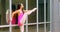 Young ballerina stretching her leg while dancing in the city 4k