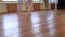 Young ballerinas begin to dance in pairs near wall with window and ballet barre durin ballet lesson.