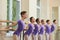 Young ballerinas doing exercises at barre.