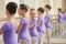 Young ballerinas rehearsing near ballet barre.