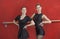 Young Ballerinas Smiling Against Red Wall