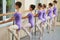 Young ballerinas training at ballet barre.