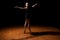 Young ballet dancer standing in a dark stage