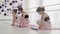 Young ballet dancers doing stretching exercises on the floor