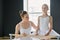 Young ballet instructor standing by youthful learner in white tutu