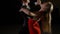 Young ballroom dance couple preform exhibition dance in studio