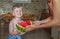 Young bare chested cheerful and happy boy gifted large water melon