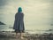 Young barefoot woman with headscarf on beach