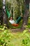 Young barefooted woman in dark sunglasses lies in hammock