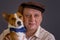 Young basenji dog wearing blue kerchief and its mature master wearing brown cap