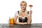 Young bavarian woman in dirndl sitting at table with beer on white background