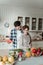 Young beaming pretty woman with big earrings and her husband cutting greens together