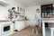 Young beaming pretty woman with big earrings preparing breakfast