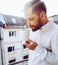 Young beard guy in a balcony taking a mug of coffee. Handsome turkish guy with brown bear