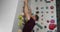 Young bearded athlete warming up arms before training on a climbing wall