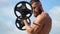 Young bearded athletic bodybuilder plays sports outdoors. Weightlifter. Bodybuilding