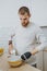 Young bearded attractive guy with artificial limb  cooks in the kitchen