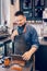 Young bearded Caucasian male man cashier barista in restaurant cafe at work.