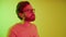 young bearded European man with glasses having a phone call via airpods medium closeup yellow background studio shot job