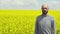 Young bearded farmer on rapeseed blooming plants