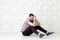 Young bearded fashion model in casual style is posing near white circle wall background. studio shot.