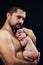 Young bearded father gently holds on his chest newborn baby daughter