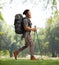 Young bearded hiker with a backpack and hiking poles walking in nature