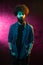 Young bearded hipster man with curly hair posing in studio in neon lights. Barbershop concept.