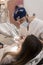 Young bearded male dentist drilling tooth to female patient