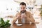 Young bearded man enjoys drinking his coffee during lunch break in the cafe, positive vibes