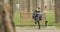 Young bearded man finishes reading a book in autumn park, gets up from bench and leaving elsewhere. Reading concept