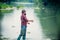 Young bearded man fishing at a lake or river. Flyfishing.