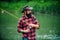 Young bearded man fishing at a lake or river. Flyfishing.