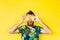 Young bearded man holding slices of pineapple in front of his eyes, surprised