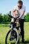 Young bearded man keen on strapping his kid to bike baby chair