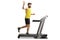 Young bearded man running on a treadmill and waving at the camera