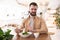 Young bearded man seems to be unhappy with his salad during lunch at the cafe, complaints and suggestions concept