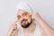 Young bearded man with towel on head, golden patches under eyes from wrinkles and dark circles, white studio background