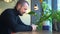 Young bearded man is using smartphone while sitting at table in cafe spbd.