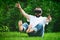 Young bearded man wearing virtual reality goggles sitting in his garden. Lifestyle VR fun