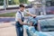 Young bearded man wiping car glass