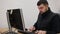 Young bearded office worker man working behind desk on computer.