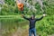 Young bearded rock musician screaming, raised up his hands with a burning guitar. backdrop of a bright summer landscape