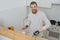 Young bearded smiling guy with artificial limb  cooks in the kitchen