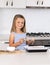 Young beautiful and adorable girl 6 or 7 years old cooking and baking at home kitchen preparing chocholate cake smiling happy and