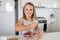 Young beautiful and adorable girl 6 or 7 years old cooking and baking at home kitchen preparing strawberry cake with bowl smiling