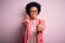 Young beautiful African American afro businesswoman with curly hair wearing pink jacket approving doing positive gesture with