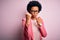 Young beautiful African American afro businesswoman with curly hair wearing pink jacket Ready to fight with fist defense gesture,