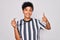 Young beautiful african american afro referee woman wearing striped uniform using whistle happy with big smile doing ok sign,
