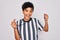 Young beautiful african american afro referee woman wearing striped uniform using whistle screaming proud and celebrating victory